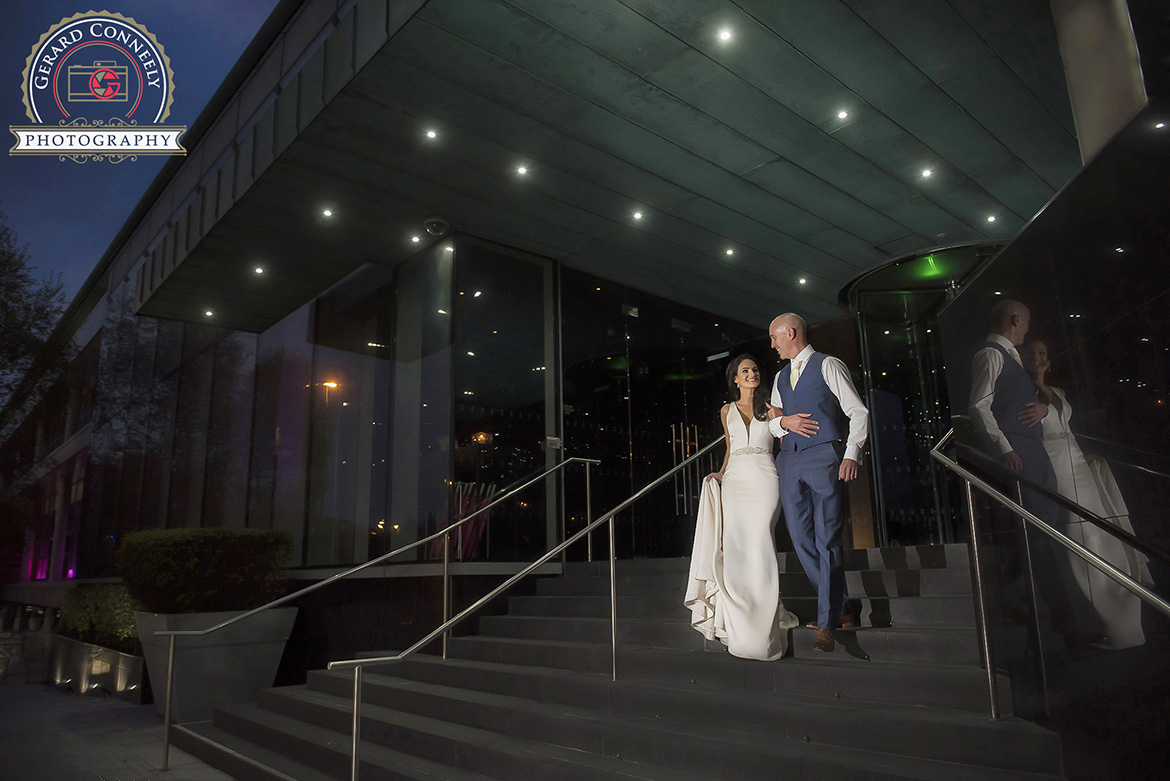 Wedding couple at the entrance to the G hotel in Galway, night time photo with off camera flash